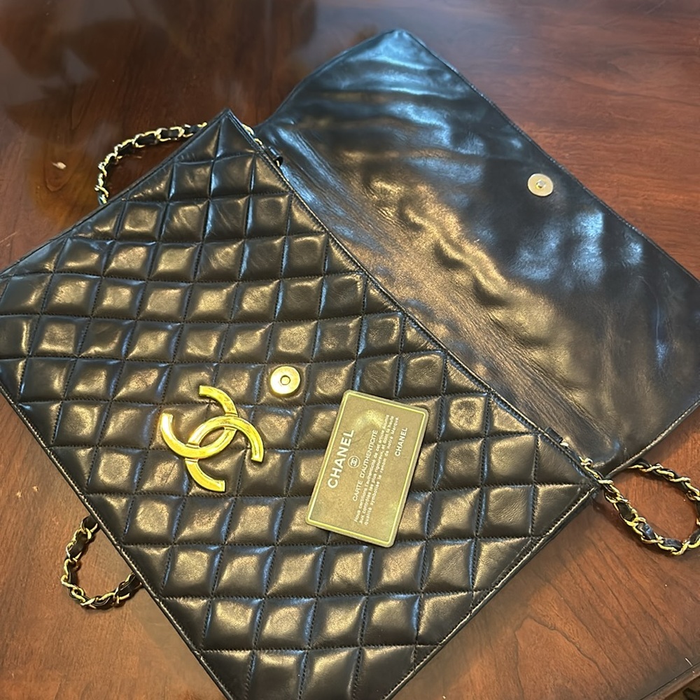 CHANEL vintage black XXL classic flap clutch bag with shoulder strap.